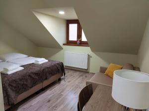 a bedroom with a bed and a couch and a table at TERRA penzión in Jasová +30 photos