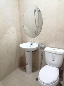 La salle de bains est pourvue de toilettes, d'un lavabo et d'un miroir. dans l'établissement มุก&พลอย เรสซิเดนซ์, à Sattahip