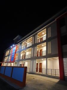 un grand bâtiment avec une façade éclairée la nuit dans l'établissement มุก&พลอย เรสซิเดนซ์, à Sattahip