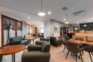 a lobby with tables and chairs and a kitchen at Rija Fonnental Design Hotel Tallinn in Tallinn