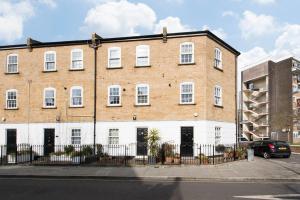 a large brick building with white windows at Lovely 2 Bedroom Family Home near Tower Bridge in London