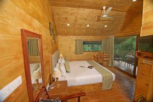 1 dormitorio con 1 cama en una habitación de madera en Spice Villa Thekkady en Thekkadi
