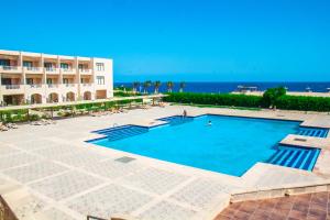 una gran piscina junto a un edificio y al océano en Viva Blue Resort and Diving Sharm El Naga (Adults Only), en Hurghada