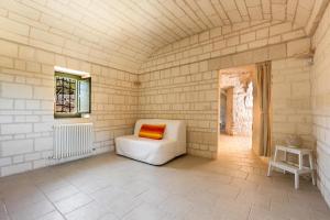 Pokój z białą kanapą i pomarańczową poduszką w obiekcie Il Trullo di Erna by BarbarHouse w mieście Ostuni