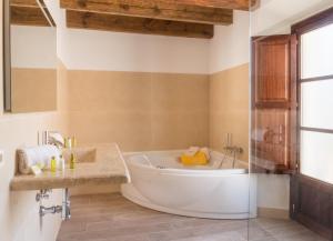 een badkamer met een groot bad en een douche bij Finca Binibona Parc Natural in Binibona