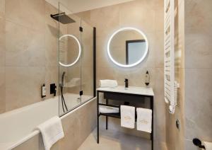 a bathroom with a sink and a tub and a mirror at Hotel Estera in Krakow