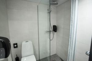 La salle de bains est pourvue d'une douche en verre et de toilettes. dans l'établissement Kääriku Hotel, à Kääriku