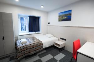 Kääriku Hotel في Kääriku: غرفة بالفندق سرير وكرسي احمر