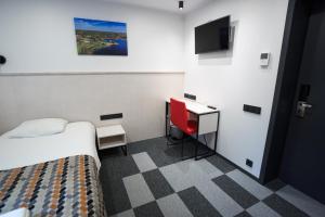 Cette chambre comprend un lit, un bureau et une télévision. dans l'établissement Kääriku Hotel, à Kääriku