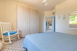 Un dormitorio con una cama azul y una silla. en Villa Dora by BarbarHouse, en San Pietro in Bevagna