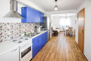 una cocina con armarios azules y un horno de fogón blanco en House Pine Shadow, en Pašman