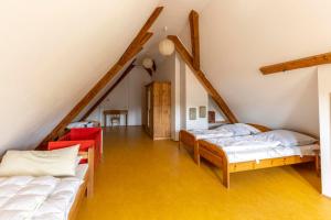 a attic room with two beds and a staircase at Bio Hofgut Wiggenweiler in Bermatingen