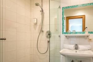 a bathroom with a shower and a sink at Hotel Garni Gästehaus Brand in Bad Wiessee +34 photos