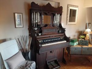 ein altes Klavier in einem Wohnzimmer mit Stuhl in der Unterkunft Acacia Gastehuis in Kathu