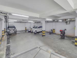 a parking garage with cars and motorcycles in it at Super OYO Capital O 90726 The Regia Cihampelas Hotel in Bandung