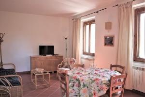 a living room with a table and chairs and a tv at Residence La Canova II in Marina di Grosseto