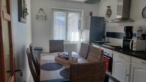 a kitchen with a table and chairs and a kitchen with a counter at APPARTEMENT, LA ROUTE DES GRANDES ALPES , 8 couchages, GARAGE pour motards, cyclistes, POSSIBILITÉ de studios supplémentaires, si plus de 8 personnes in Fourneaux