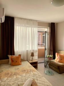 a bedroom with a bed and a window and a couch at Guest House FAMILY in Plovdiv