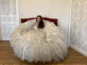 Eine Frau in einem Hochzeitskleid, die auf einem Bett liegt. in der Unterkunft chambre romantique dans le château de la Bouchatte in Chazemais