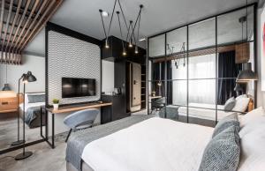 Schlafzimmer mit einem Bett, einem Schreibtisch und einem TV in der Unterkunft 7 Rooms Suites in Belgrad