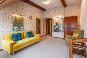 a living room with a yellow couch and blue pillows at Alexander House in Saint Petersburg