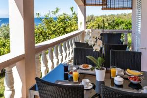 a table with food and drinks on a balcony at Apartments Separovic in Prizba