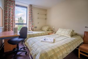 a hotel room with a bed and a desk and a window at LSE Rosebery Hall in London