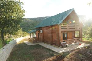 a log cabin with a bench in front of it at Holiday Home Skadar Lake in Arbneš