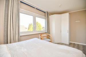 een slaapkamer met een bed en een groot raam bij Haus Meeresrauschen Sansibar in Scharbeutz