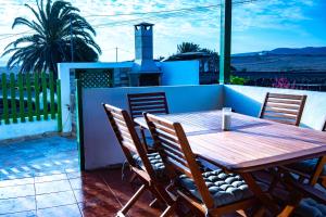 einen Holztisch und Stühle auf einer Terrasse in der Unterkunft Casa Antoñita, El lugar perfecto para descansar in Muñique