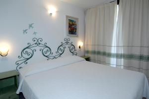 a bedroom with a white bed and a window at Sardegna Beach Eucalyptus in Golfo Aranci +30 photos