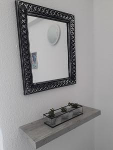 a mirror on a wall with a shelf at Panoramic View Atlas Loutraki in Loutraki