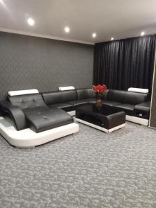 sala de estar con sofá negro y mesa en Ely's Mansion-24h Check-in, en Bucarest