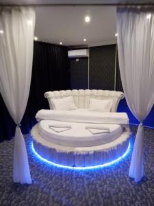 een bed in een kamer met 2 witte gordijnen bij Ely's Mansion-24h Check-in in Boekarest