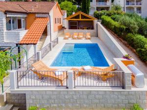 an image of a swimming pool with chairs and a house at Holiday Home Villa Frančeska in Postira
