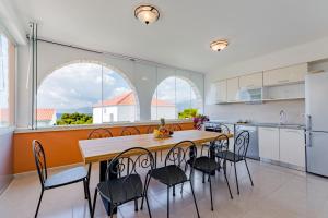 a kitchen with a table and chairs in a kitchen at Holiday Home Villa Frančeska in Postira