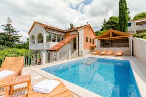 a villa with a swimming pool and a house at Holiday Home Villa Frančeska in Postira