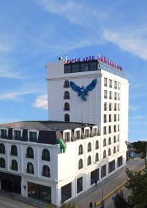 un gran edificio blanco con un cartel encima en Grande Arte Hotel en Eskisehir