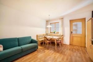 - un salon avec un canapé vert et une table dans l'établissement Egarthof Ferienwohnung Arnika, à Moso in Passiria