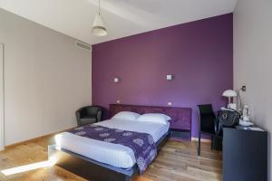 Dormitorio púrpura con cama y pared púrpura en Hôtel Château La Chèze - Bordeaux Floirac, en Floirac