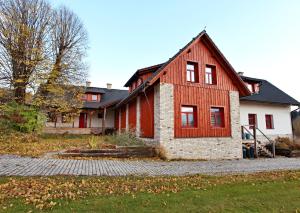 een groot rood-wit huis met een tuin bij Ateliér 673 in Dolní Bečva