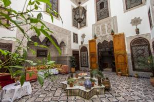 ein Wohnzimmer mit Möbeln und Pflanzen in der Unterkunft Pacha Palace in Fès