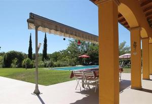un patio con mesa y sillas junto a una piscina en Idyllic guest wing of villa, en Sales del Llierca