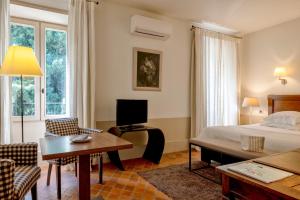 a hotel room with a bed and a desk and chairs at Le Prieure in Villeneuve-lès-Avignon