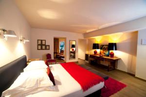 a bedroom with a large bed and a desk at Le Prieure in Villeneuve-lès-Avignon +29 photos