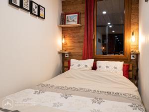 a small bedroom with a bed with a window at Le Cocon de l'Arcelle in Lanslevillard