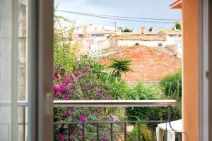 a window view of a garden with pink flowers at Hauzify I Apartament Capmany in Sant Feliu de Guíxols