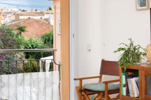 a room with a balcony with a chair and a window at Hauzify I Apartament Capmany in Sant Feliu de Guíxols