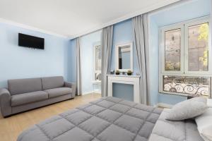 een slaapkamer met een bed, een bank en ramen bij Rhome Hosting in Rome