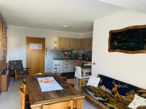Casa Vacanza DELLE OROBIE في Cedrasco: غرفة معيشة مع طاولة ومطبخ